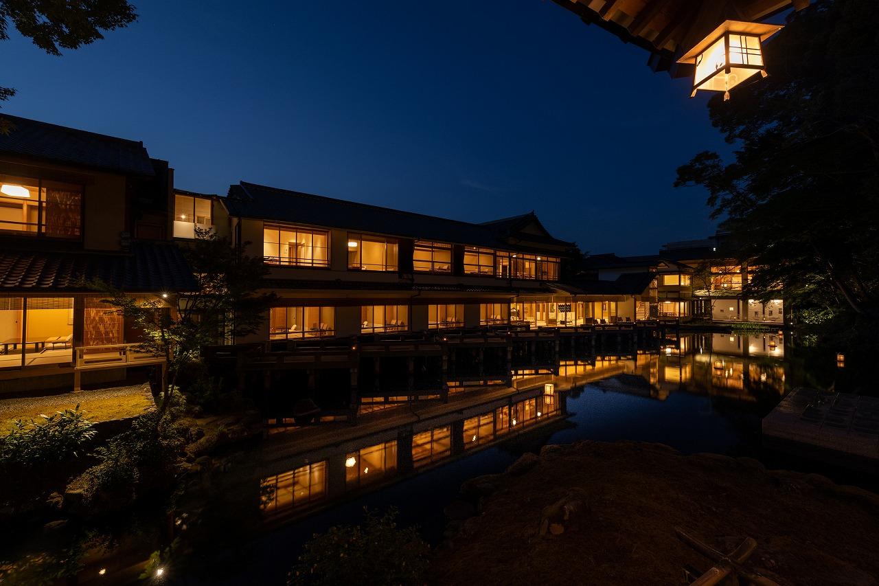 Traditional Japanese ryokan illuminated at night with reflection on water Japan