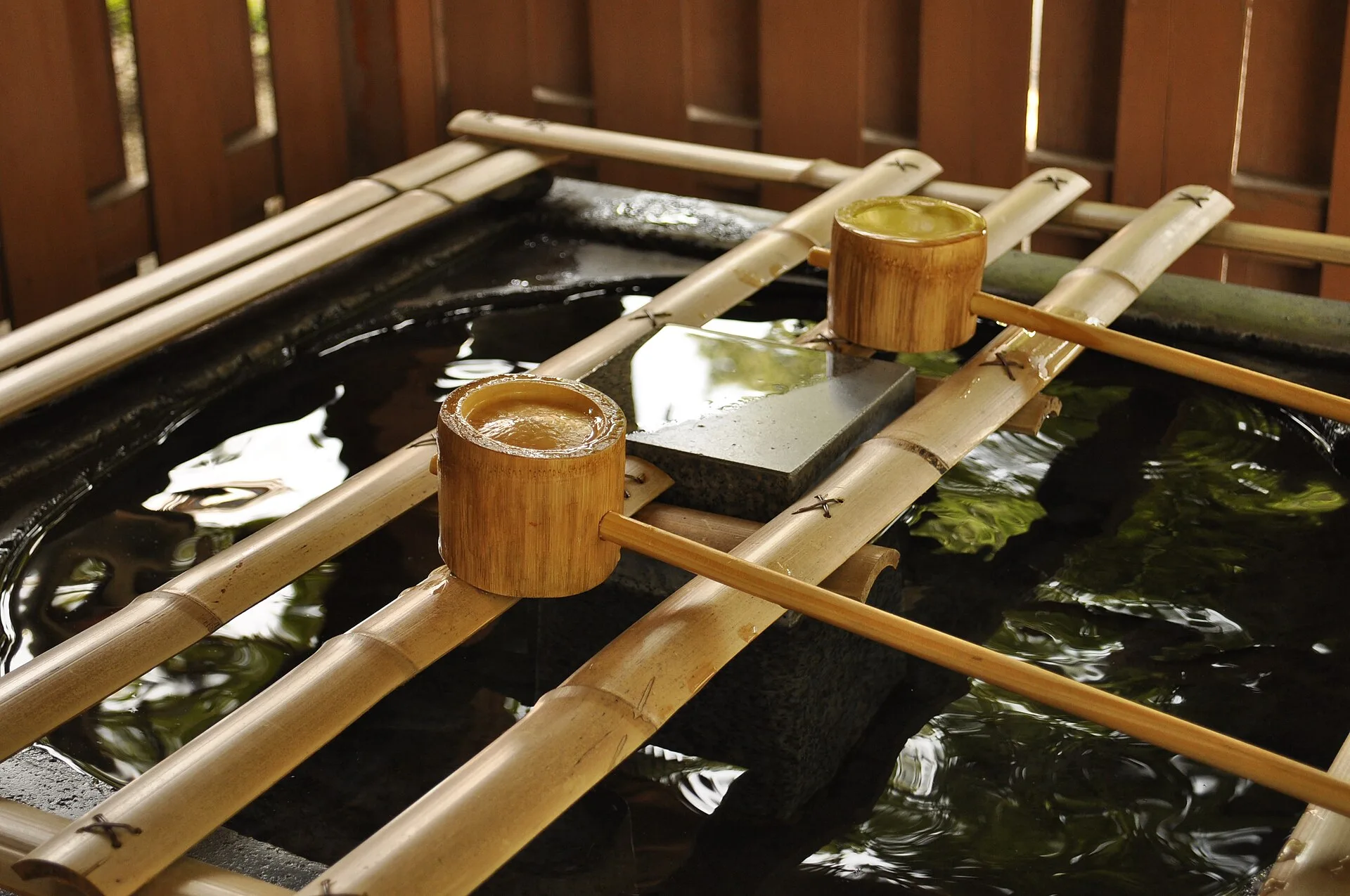 Stone temizuya purification fountain with bamboo ladles at a Japanese shrine