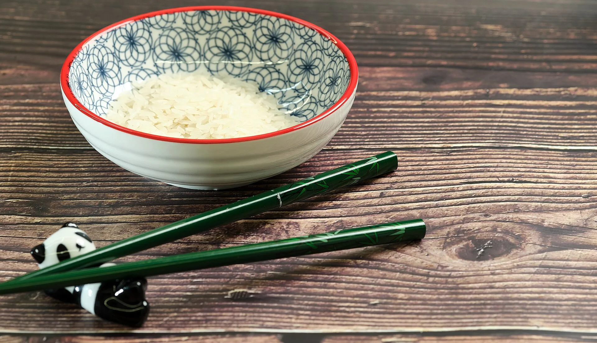 Chopsticks resting on a small chopstick rest on a table